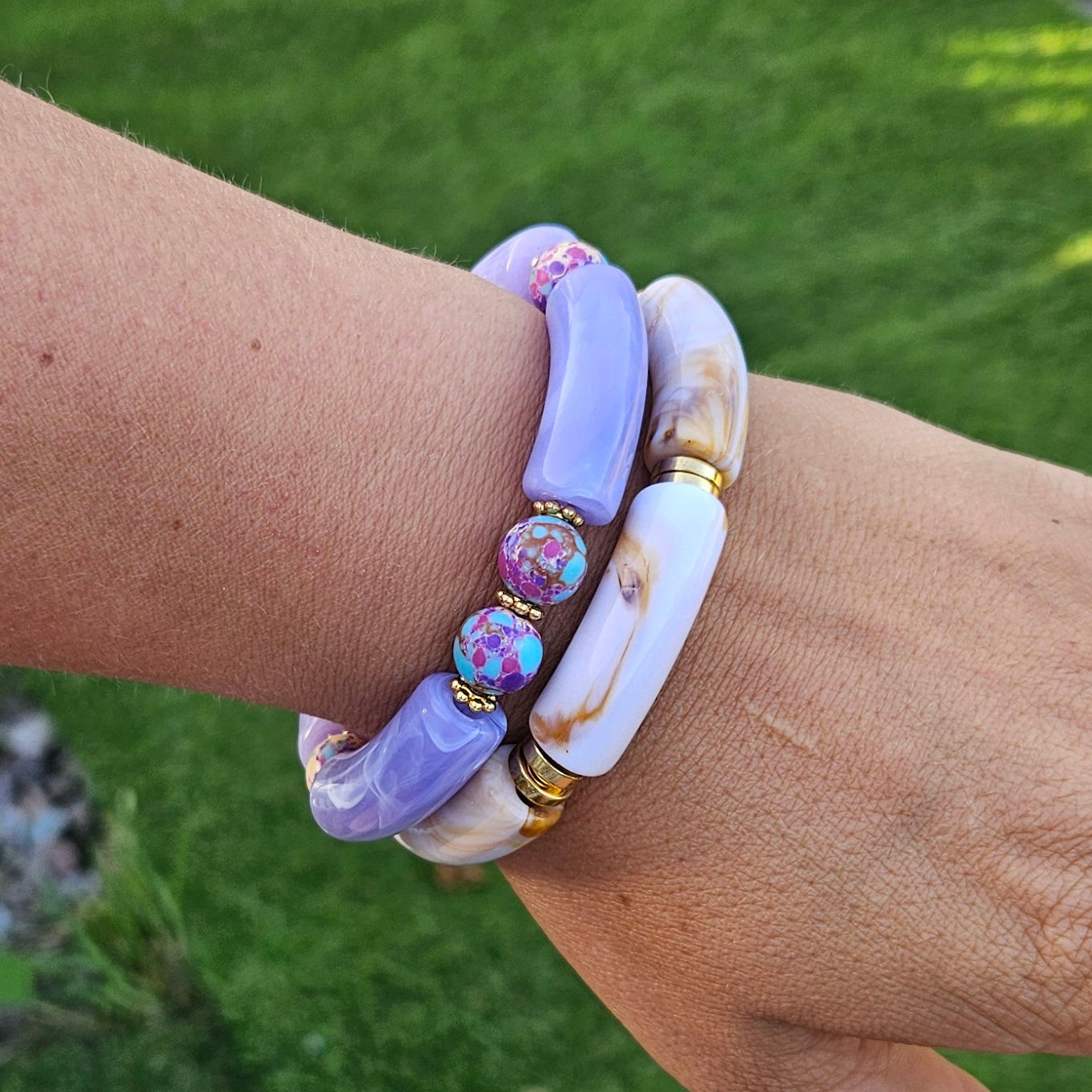 Woman wearing the Galaxy Skies Bracelet stacked with other Fleur & Stone bracelets in natural outdoor light.