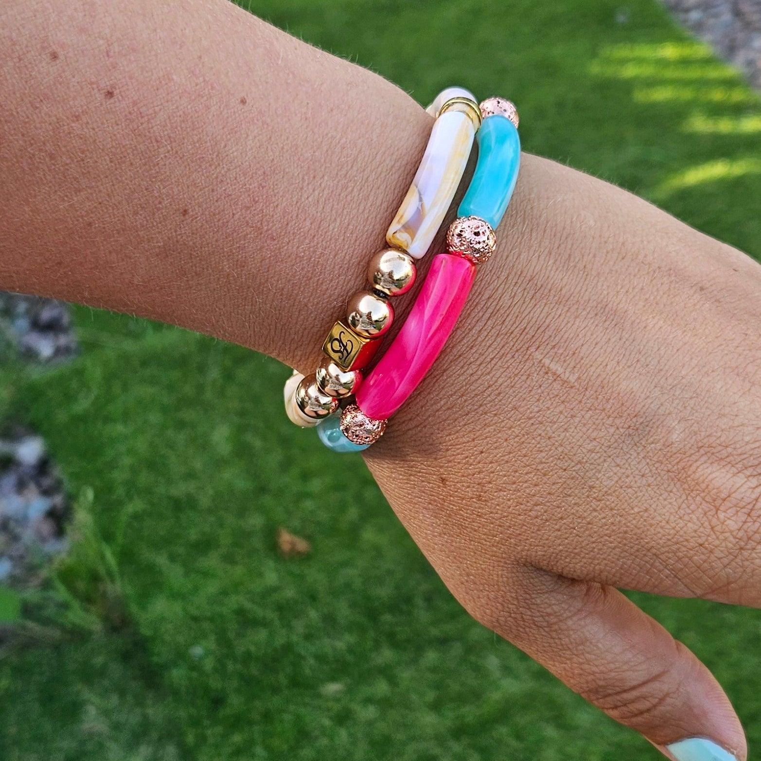 Woman wearing the Pink Lagoon Bracelet by Fleur & Stone featuring turquoise and pink acrylic tube beads with textured rose gold lava beads.