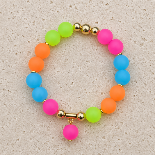Tutti Frutti neon silicone bracelet with colourful 12 mm beads, gold accents and pink dangling charm by Fleur & Stone.