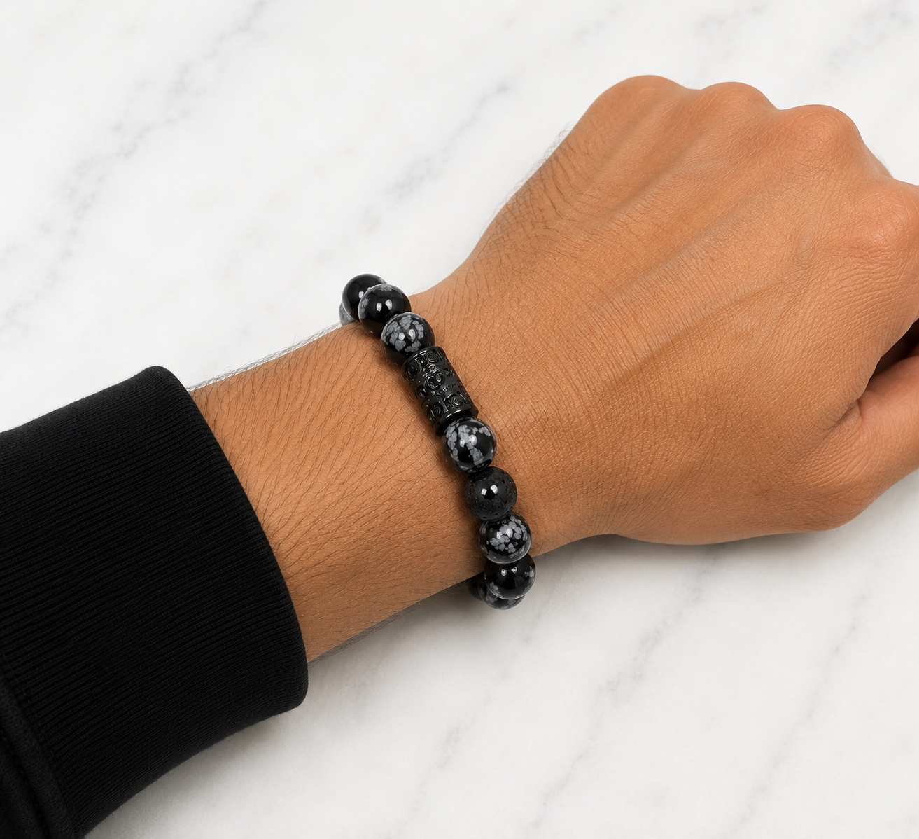 Snowflake Obsidian & Lava Stone bracelet worn on a man's wrist showing the fit of the 10mm gemstone bracelet.