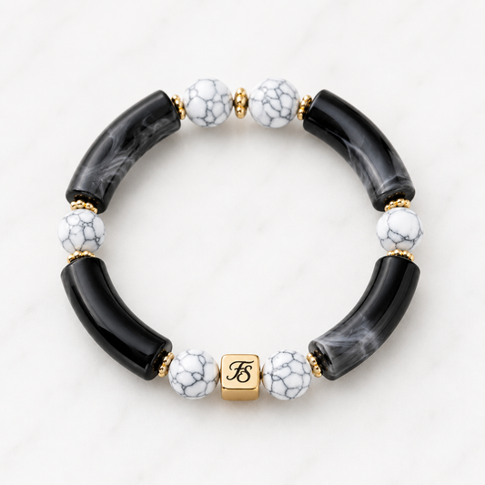 Make a statement with the Midnight Marble Bracelet, handcrafted in County Kerry with black marbled acrylic, white howlite gemstone beads, gold hematite accents, and our signature Fleur & Stone logo bead.