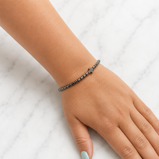 4mm Natural Hematite Cross bracelet worn on a woman's wrist showing the fit of the polished Hematite bracelet.
