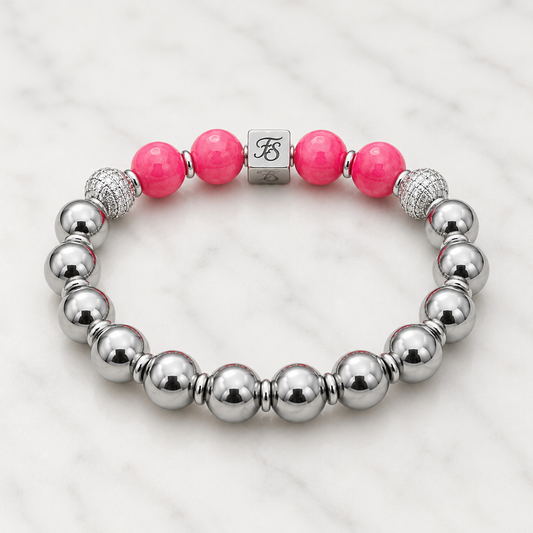 Natural Rhodochrosite and Silver Hematite gemstone bracelet with 10mm beads, silver rhinestone spacers and stainless steel Fleur & Stone logo bead on a light white marble background.