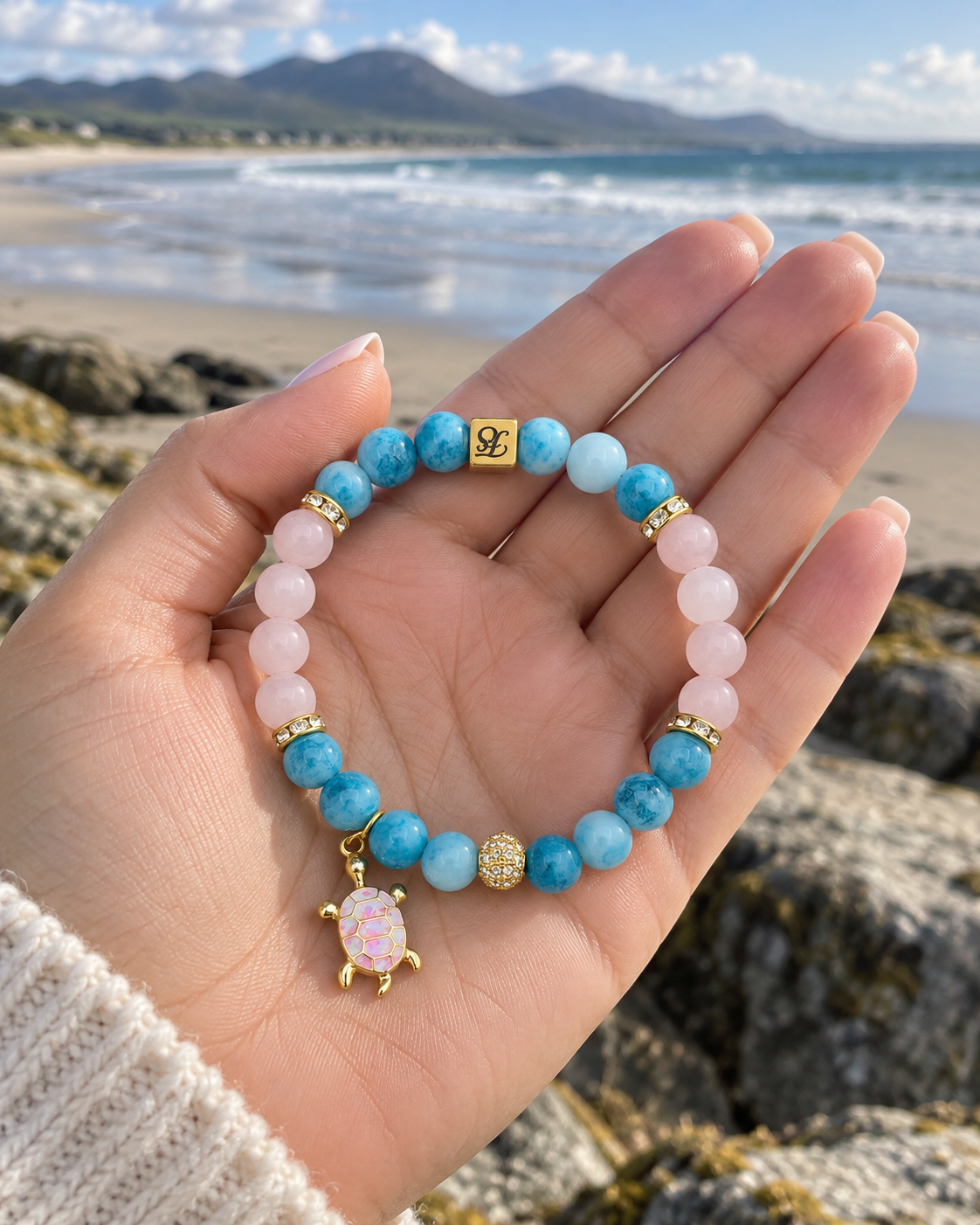 Coastal Rose Larimar and Rose Quartz gemstone bracelet held by hand on the Kerry coast